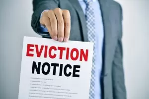 How to Increase Rent or Evict Seasoned Tenants man with an eviction notice
